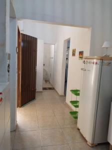 伯迪亚哥Casa a 5 minutos a pé da Praia da Enseada!的客房设有带冰箱和卫生间的走廊