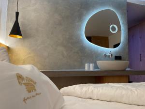塞尔瓦迪加尔代纳山谷Hotel Des Alpes的卧室配有水槽和墙上的镜子