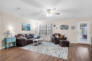 微风湾Gulf Breeze - Canal front, Near Beach & Downtwn 3BR-2BT的客厅配有两张沙发和吊扇