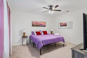 巴吞鲁日Chic Townhouse by LSU的一间卧室配有一张紫色的床和吊扇