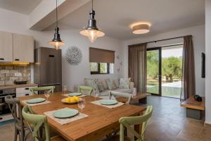 普莱诺斯Astarte Villas - Petra Elia Private Villa with Pool的厨房以及带木桌和椅子的用餐室。