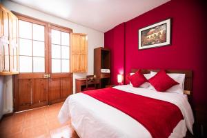 阿雷基帕斯拉尔酒店的红色卧室配有一张带红色枕头的大床