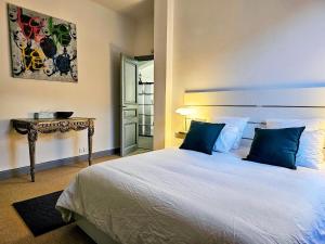 图卢兹L'Idrac, Appartements en Hyper centre的一间卧室配有一张带蓝色枕头的床和一张桌子