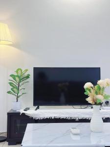 芙蓉Ninja's Sweet Home的客厅配有电视和鲜花桌