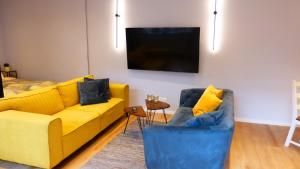 不来梅港City Studio Kormoran的客厅配有黄色沙发和2把蓝色椅子