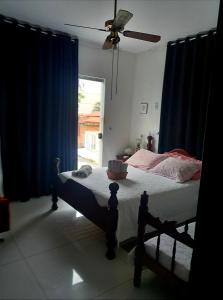 沃尔塔雷东达Pousada Flor de Lis Homestay的一间卧室配有一张带蓝色窗帘的床和一扇窗户