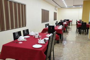 菩提伽耶HOTEL MARIYA INTERNATIONAL的一间用餐室,配有红色的桌椅和红色的桌布