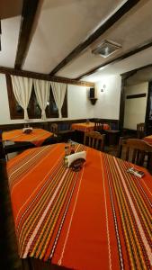 韦林格勒老房子家庭酒店的用餐室配有带橙色桌布的桌子