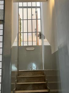 卡塔尼亚Dimora sicula guest house的楼梯通往带窗户的门
