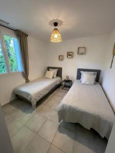 阿洛ALLAUCH VILLAGE DE PAGNOL的一间卧室配有两张床和吊灯。
