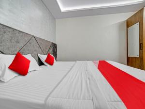 贾姆谢德布尔All Seasons Corporate的卧室配有带红色枕头的白色床