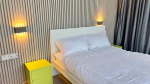 苏尔Wadi Shab Beach Villa的一间卧室配有白色的床和两盏灯