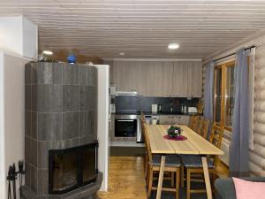 VuoriniemiVilla Saimaa的厨房以及带壁炉和桌子的用餐室。