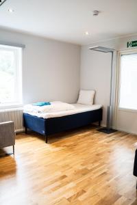 HärrydaLandvetter Hotell的铺有木地板的客房内设有一间卧室和一张床。