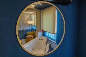 伊斯坦布尔Ayramin Deluxe Hotel Taksim的一间带圆形镜子浴缸的浴室