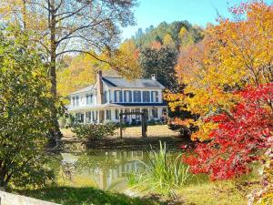 赛维尔维尔Historic Seaton Springs Farm B&B - M Seaton Queen Room with Private Bath down the hall的前面有池塘的大房子