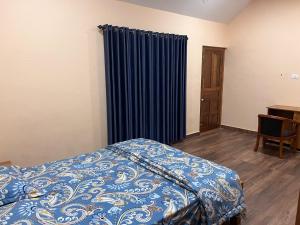 ThirunelliCoffee Bean Rest House的一间卧室配有床和蓝色窗帘