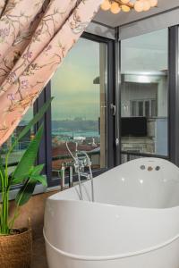 伊斯坦布尔阿拉敏塔克西姆酒店的带浴缸的浴室和大窗户
