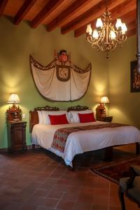 圣米格尔-德阿连德Casa Don Pascual Hotel Boutique Sweet Home的一间卧室配有两张床和吊灯。