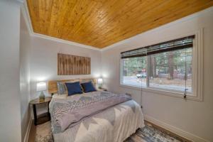 南太浩湖Moose and Maple Lodge的一间卧室设有一张大床和一个窗户。