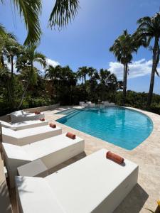 德赛Residence AU 'TI SUCRIER的一个带白色躺椅的游泳池和一个游泳池