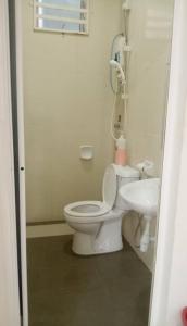 PakaHomestay Taman Tiara Paka的白色的浴室设有卫生间和水槽。