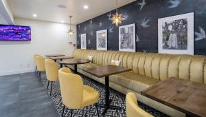 圣马特奥市The Catrina Hotel的餐厅设有木桌和黄色椅子