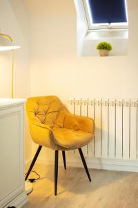 奥拉迪亚Kasa Nouveau的黄色椅子坐在窗户的房间