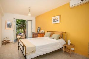 舍尔谢Villa Sol Y Sombra的一间卧室设有一张床和黄色的墙壁