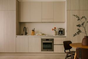 洛杉矶Sonder The Craftsman的厨房配有白色橱柜和桌子