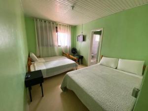 帕苏丰杜Pousada355的绿色的客房设有两张床和窗户。