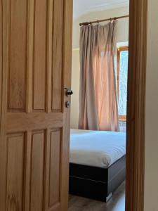 迪利然Verin Tun的一间卧室配有一张床,一扇门设有窗户
