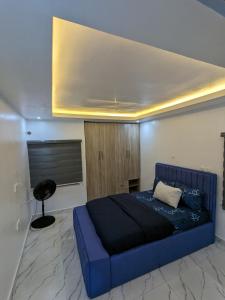 哈科特港Easyinn Shortlet Apartment的一间位于客房内的蓝色床卧室