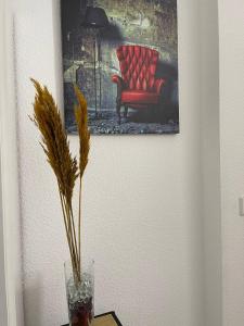 乌尔班Rheinview Sunset in Urbar的一张红椅子和一张桌子上的花瓶的照片