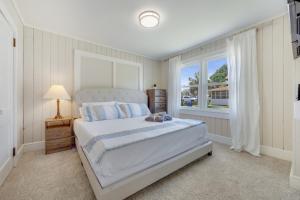 默特尔比奇200ft to beach! North Myrtle Beach first level duplex home, pet friendly!的白色的卧室设有床和窗户