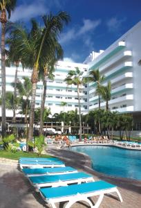 迈阿密海滩Riu Plaza Miami Beach的游泳池旁的一排躺椅