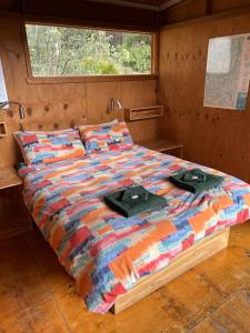 新诺福克塔斯马尼亚露营地的一张床上有两顶帽子的房间