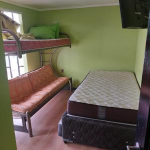 科金博Coco Cris Hostal的一间带两张双层床和一张沙发的卧室