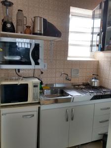 因贝Apto Central Barra de Imbé的带微波炉和水槽的小厨房