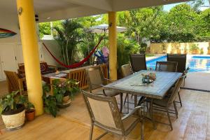 埃斯孔迪多港Zandoyo Bed & Breakfast的一个带桌椅的庭院和一个游泳池