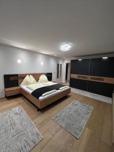 比绍夫斯霍芬Ferienwohnungen Bischofshofen的一间卧室配有一张大床和两张地毯。