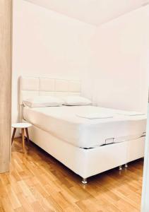 布德瓦Monte Star apartments的铺有木地板的客房内的一张白色床