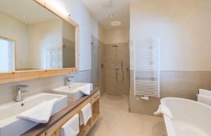 瓦兹格鲁那尔霍夫酒店的一间带两个盥洗盆和淋浴的浴室