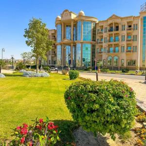 开罗Ramage Hotel & Resort的前面有绿色草坪的大建筑