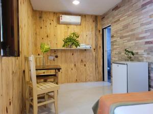 皮帕Casa de Dan的厨房设有木墙、桌子和冰箱。