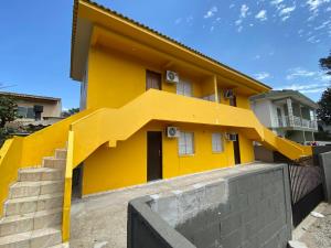弗洛里亚诺波利斯Apartamento cachoeira的前面有楼梯的黄色房子