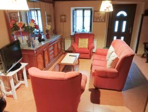 Poo de CabralesCasa Pelayo 2的客厅配有红色椅子和电视