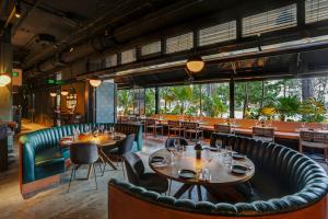 迈阿密海滩Urbanica Euclid的餐厅设有桌椅和大窗户。
