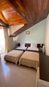 里贝拉布拉瓦Bela Sombra的卧室设有两张床铺和木制天花板