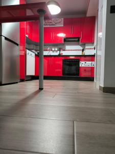隆达Casa Daybru的厨房配有红色橱柜和不锈钢用具